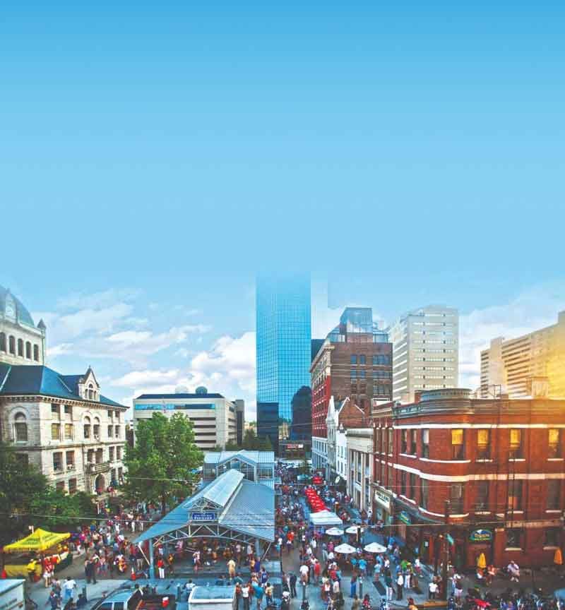 modern and old buildings line a street full of people