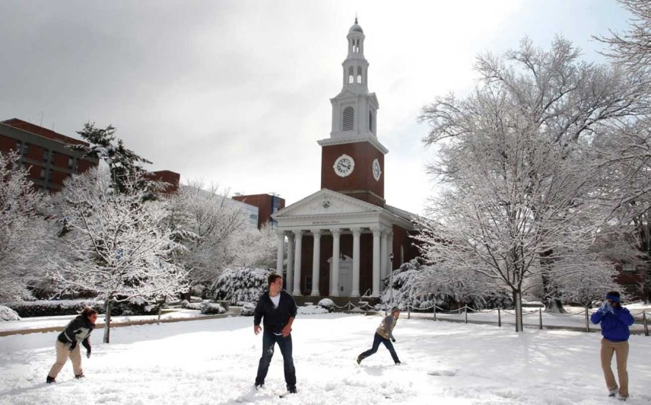 a group of students having a snowball fight on campus