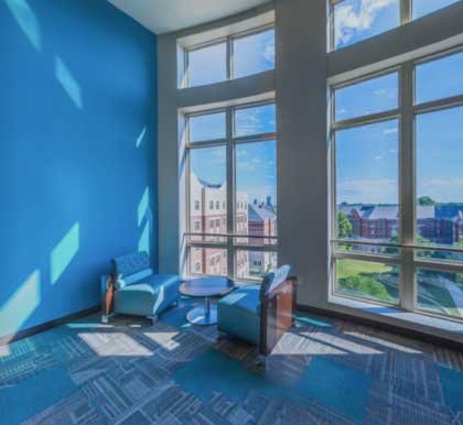 a blue room with large windows overlooks campus