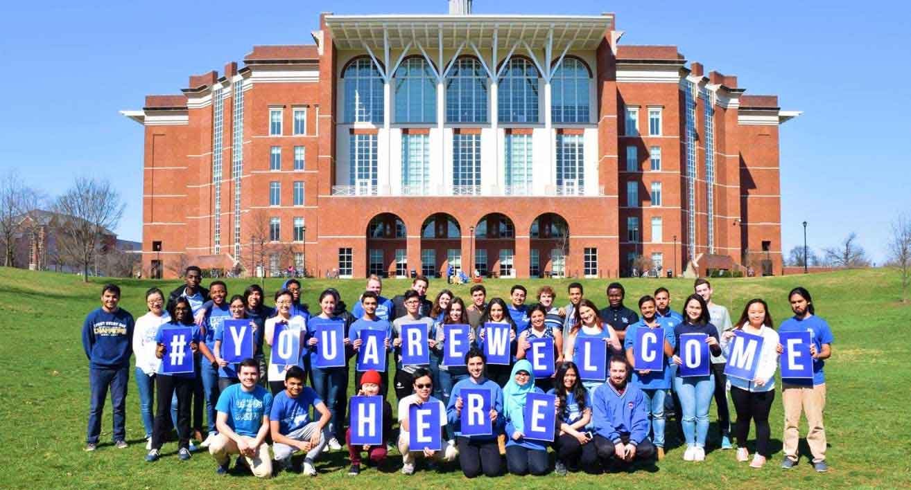 students hold signs spelling "You Are Welcome Here"